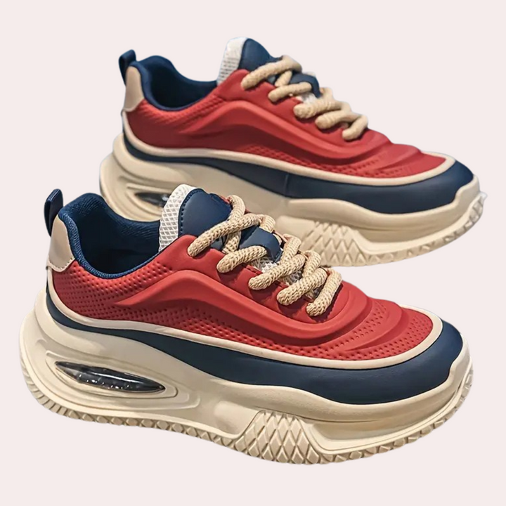 Rote und blaue Sneaker mit dicker Sohle, beige Schnürsenkel, sportliches Design.