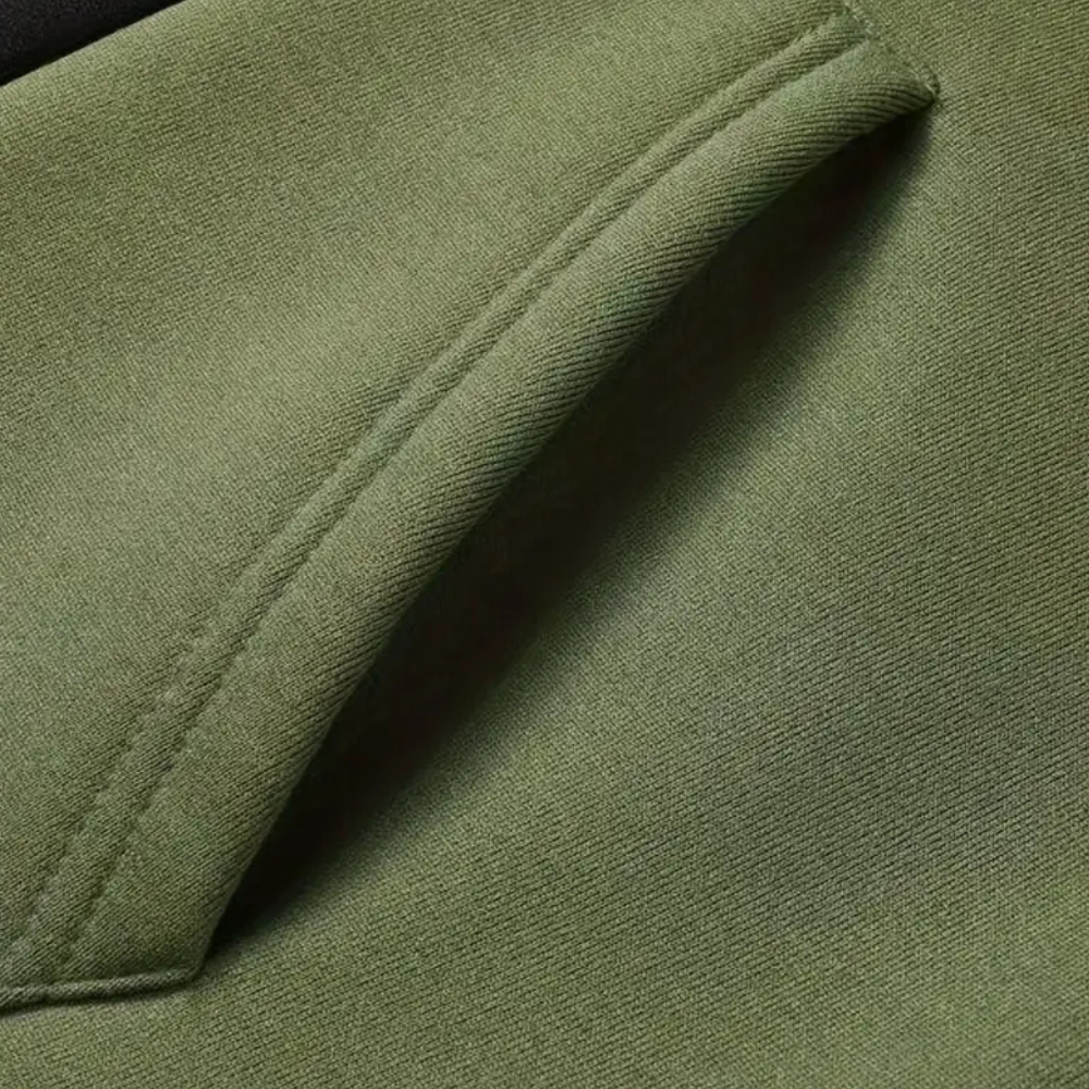 Grüne Baumwolljacke mit Tasche, Nahaufnahme, hochwertige Outdoor-Bekleidung, langlebig.