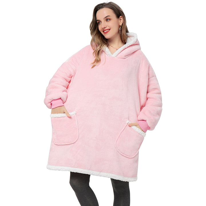 Frau in rosa Oversize-Kapuzenpullover, flauschig, warm, mit Taschen, gemütliche Wintermode.