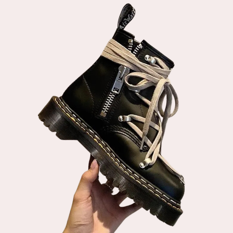 Schwarzer Lederstiefel mit Reißverschluss und Schnürsenkeln, handgehalten, modisch, robust.