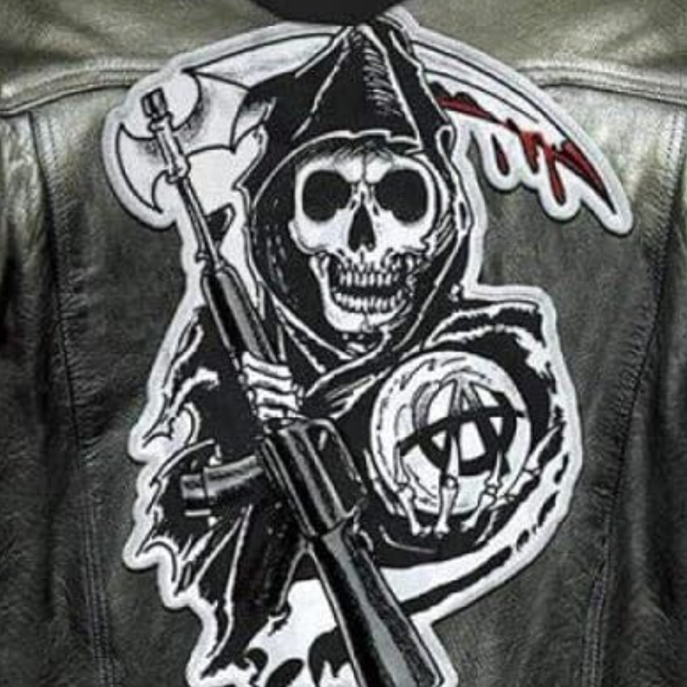 Schwarze Lederjacke mit Totenkopf-Aufnäher, Sense und Gewehr, Gothic-Mode, Punk-Stil.