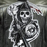 Schwarze Lederjacke mit Totenkopf-Aufnäher, Sense und Gewehr, Gothic-Mode, Punk-Stil.
