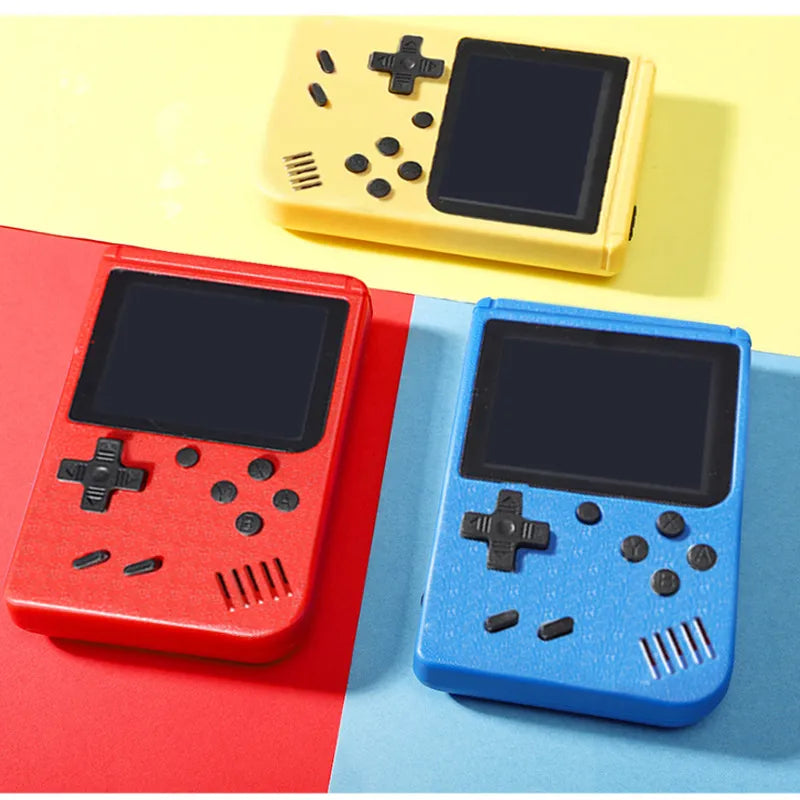 Drei tragbare Retro-Spielkonsolen in Rot, Blau und Gelb auf buntem Hintergrund.