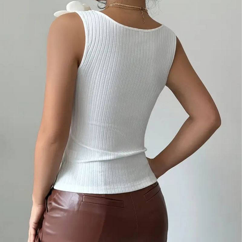 Frau in weißem, ärmellosem Ripptop und brauner Lederhose von hinten.