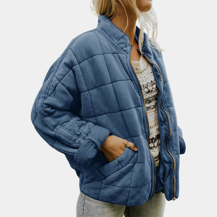 Frau in blauer Steppjacke, Reißverschluss, lässig, modisch, Herbstkleidung, Damenmode.