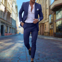 Mann im blauen Slim-Fit-Anzug auf Kopfsteinpflasterstraße, eleganter Herrenmode-Look.