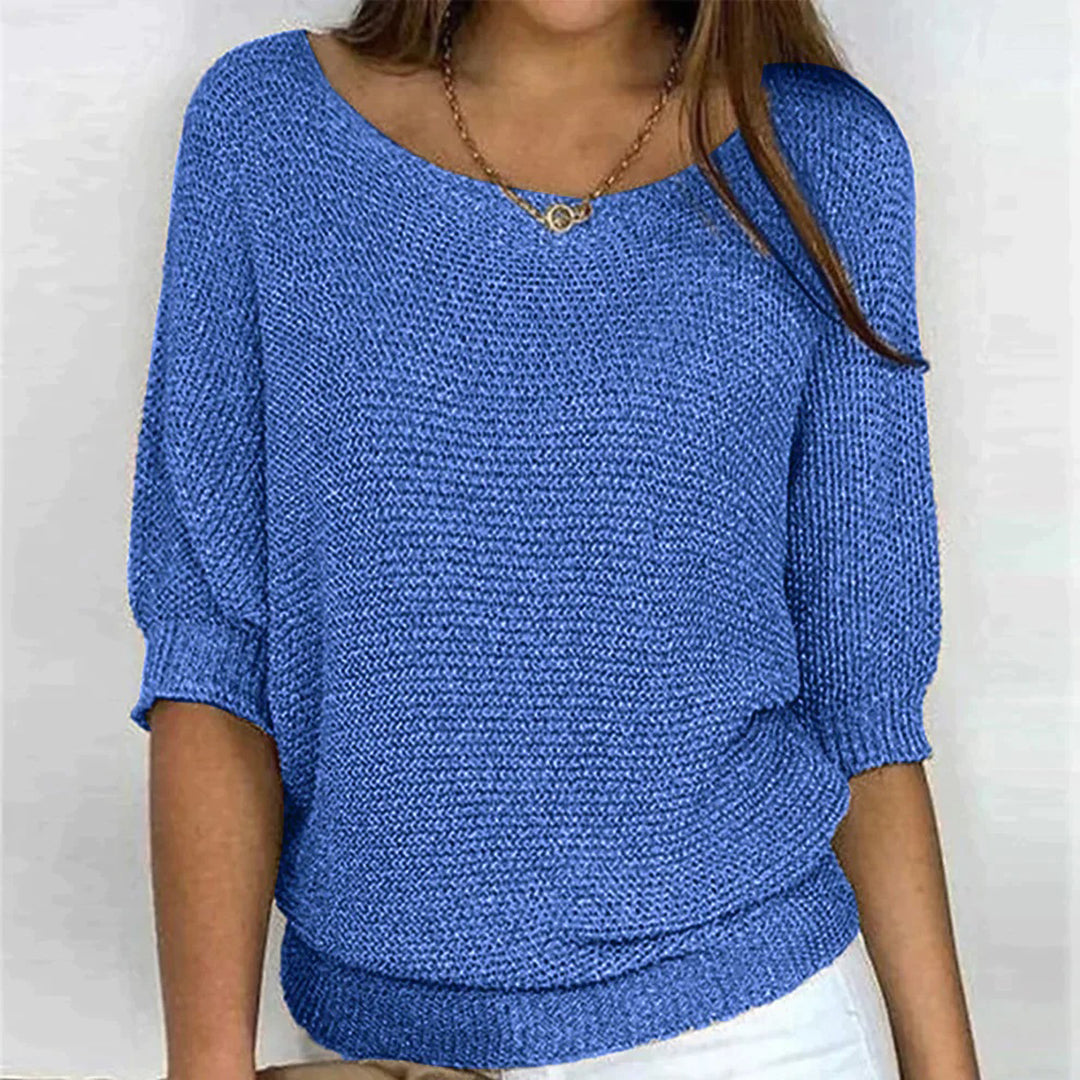 Frau trägt blauen Strickpullover, lässiger Stil, Dreiviertelärmel, modisch, bequem.