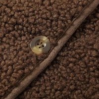 Brauner Fleece-Stoff mit Knopf, Textur, Detailaufnahme, Mode, Bekleidungsmaterial, Nahaufnahme.