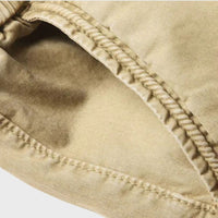 Beige Cargohose für Herren, Detailansicht, Baumwolle, robuste Nähte, modische Freizeitkleidung.
