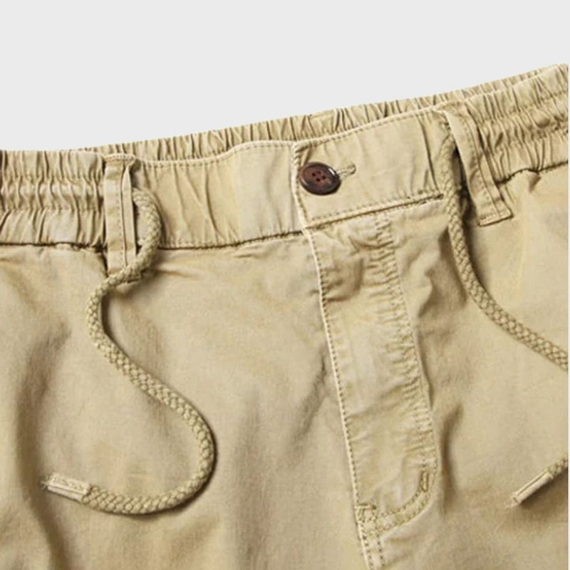 Beige Cargohose für Herren mit Kordelzug, elastischem Bund und Knopfverschluss.