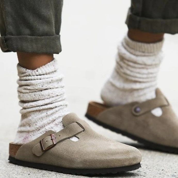 Beige Wildleder-Clogs mit Schnalle, getragen mit weißen Socken, modische Damen-Schuhe.