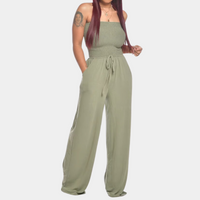 Frau in grünem Jumpsuit mit weitem Bein, ärmellos, modisch, bequem, Sommerkleidung.