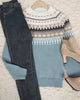 Damen-Winterpullover mit Norwegermuster, blau-weiß, kombiniert mit Jeans und beigen Stiefeletten.