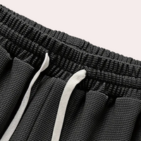 Schwarze Sportshorts mit elastischem Bund und weißen Kordeln, atmungsaktives Material.