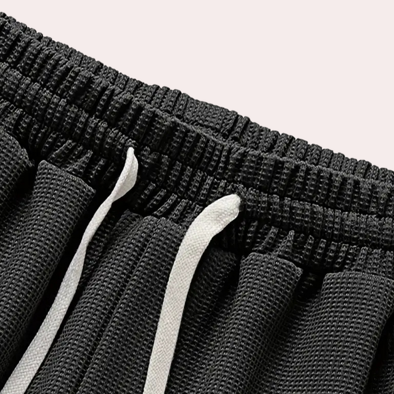 Schwarze Sportshorts mit elastischem Bund und weißen Kordeln, atmungsaktives Material.
