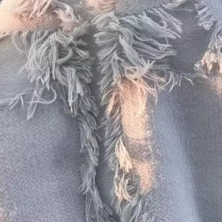 Grauer Strickschal mit Fransen, weiches Material, modisches Accessoire, Winterkleidung.