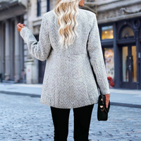 Frau in grauem Wollmantel auf Kopfsteinpflasterstraße, stilvolle Herbstmode, Stadtbummel.