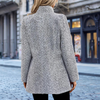 Frau in grauem Wollmantel auf Kopfsteinpflasterstraße, stilvolle Wintermode.