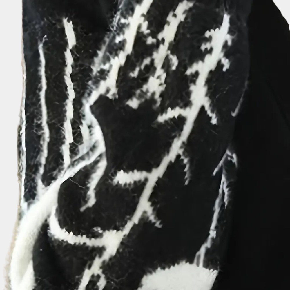 Schwarz-weißer Wollschal mit abstraktem Muster, warmes Winteraccessoire, modisch und elegant.