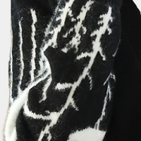 Schwarz-weißer Wollschal mit abstraktem Muster, warmes Winteraccessoire, modisch und elegant.