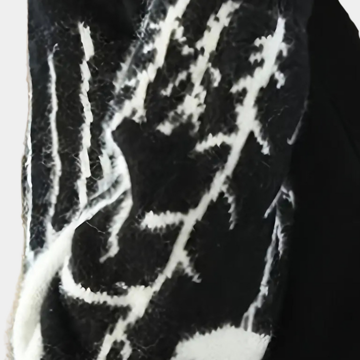 Schwarz-weißer Wollschal mit abstraktem Muster, warmes Winteraccessoire, modisch und elegant.