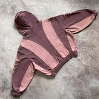 Rosa und brauner Kapuzenpullover, gestreift, aus Baumwolle, lässig, modisch, auf Betonboden.