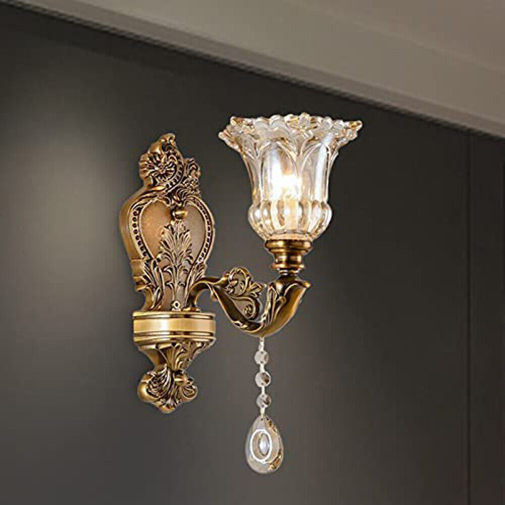 Klassische goldene Vintage-Wandleuchte mit Glaslampenschirm und dekorativem Kristallanhänger.