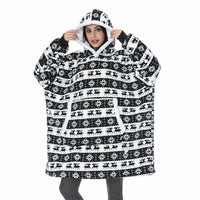 Frau in schwarz-weißem Oversize-Hoodie mit Rentiermuster, gemütliche Winterkleidung.