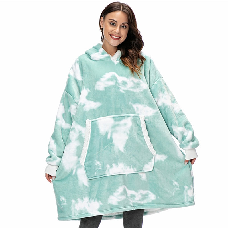 Frau in mintgrünem Oversize-Hoodie-Decke mit Wolkenmuster, gemütliche Kleidung.