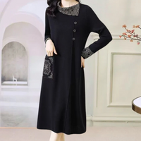 Schwarzes Damenkleid mit langen Ärmeln, Spitzenmuster, Knöpfen, elegant, modisch.